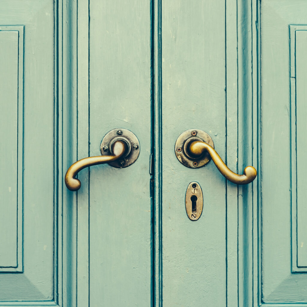πόρτα ξύλινη σε πράσινο χρώμα με πόμολα vintage σε χρυσό